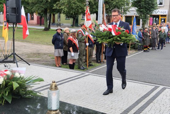 Kwiaty pod pomnikiem składa Wojciech Brzeski z Zarządu Powiatu Zgierskiego.