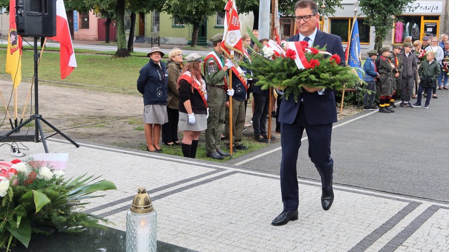 Kwiaty pod pomnikiem składa Wojciech Brzeski z Zarządu Powiatu Zgierskiego.