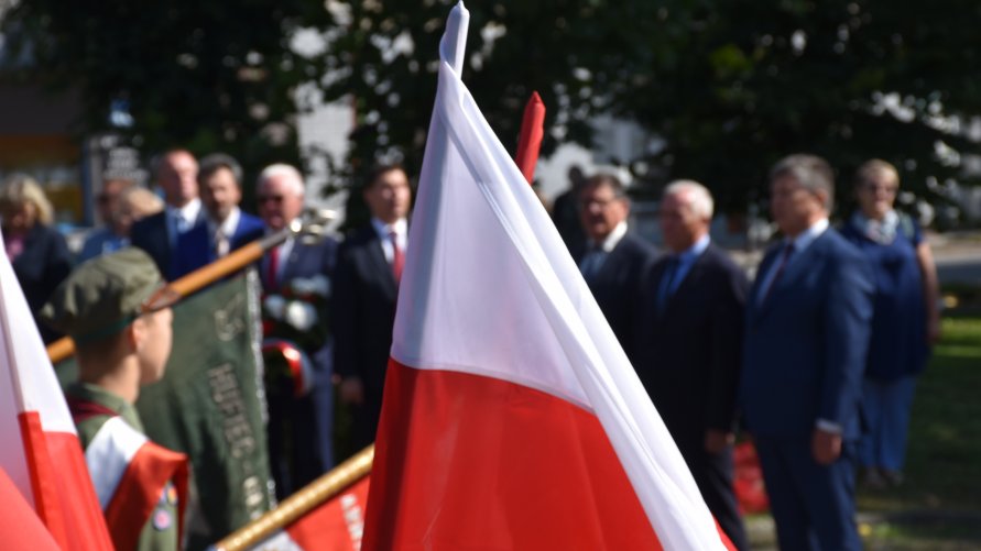 Flaga Polski na tle uroczystości w Głownie